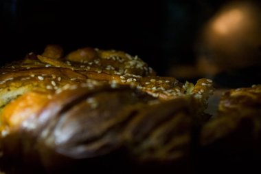 Lezzetli ev yapımı hamur işleri. Tuzlu susamlı turta. Siyah arka plan.