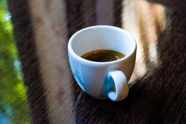 Tazza in ceramica bianca da espresso su superficie marrone lucido. Caffè e buongiorno. Contesto . — Foto Stock