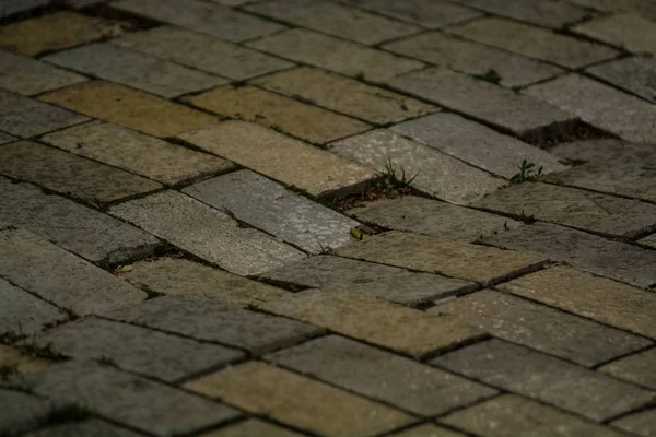 Hintergrund oder Textur von einer gebrochenen und gleichen Fliese mit Lichtflecken und Tropfen. Steinblöcke auf dem Bürgersteig. — Stockfoto
