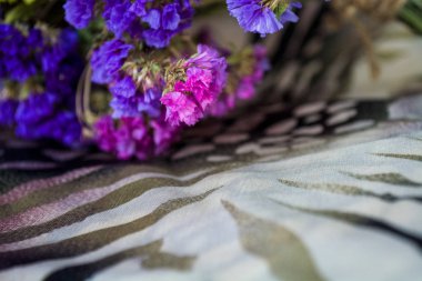 Leopar ve zebra baskılı bez üzerine tarla ve kurak çiçekler buketi.