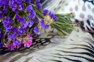 Leopar ve zebra baskılı bez üzerine tarla ve kurak çiçekler buketi.