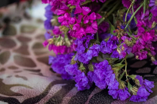 Bouquet of field and arid flowers on cloth with leopard and zebra print.