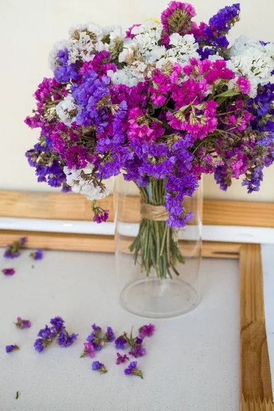 A bouquet of field purple flowers in a glass flask. Vase. Still life. White background.