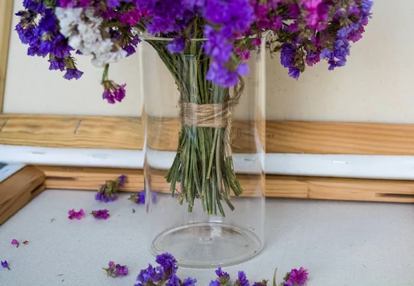 A bouquet of field purple flowers in a glass flask. Vase. Still life. White background.