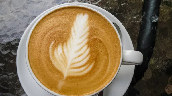 Atas Meja Kaca Terdapat Cangkir Putih Cappuccino Dan Seni Latte — Stok Foto