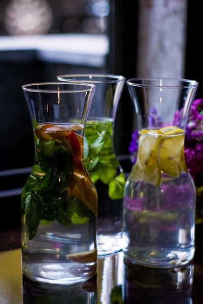 Useful and beautiful water with mint and fruit in glass pitcher. Glasses. Detox. Natural lemonade.