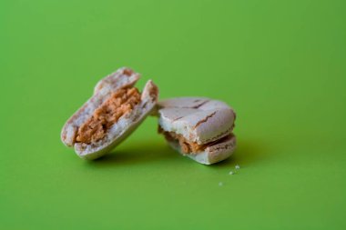 Bir ton yeşil arka plan üzerinde bir kırık makarna zevkle tuzlu karamel. Fransız tatlısı. Tatlı