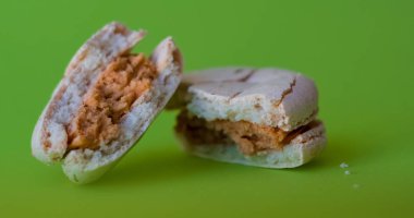 Bir ton yeşil arka plan üzerinde bir kırık makarna zevkle tuzlu karamel. Fransız tatlısı. Tatlı