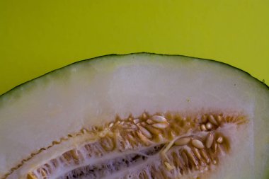 Bir ton yeşil arka plan üzerinde tohumları ile kesilmiş olgun kavun yarısı. Faydalı meyveler. Yaz. Sezon. Vitamin.