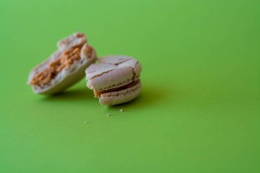 Bir ton yeşil arka plan üzerinde bir kırık makarna zevkle tuzlu karamel. Fransız tatlısı. Tatlı.