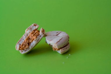 Bir ton yeşil arka plan üzerinde bir kırık makarna zevkle tuzlu karamel. Fransız tatlısı. Tatlı.