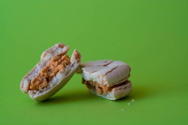 Bir ton yeşil arka plan üzerinde bir kırık makarna zevkle tuzlu karamel. Fransız tatlısı. Tatlı.