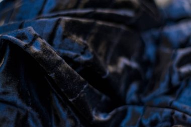 Siyah ve sade, yanardöner, kadife, kıvrık kumaş. Perde.