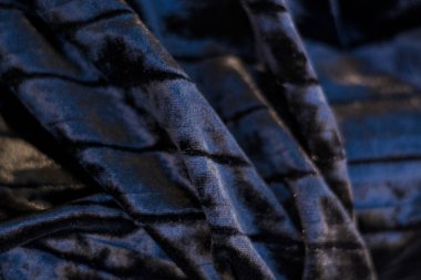 Siyah ve sade, yanardöner, kadife, kıvrık kumaş. Perde.