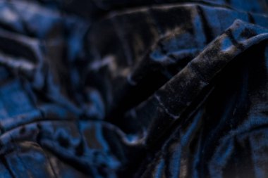 Siyah ve sade, yanardöner, kadife, kıvrık kumaş. Perde.