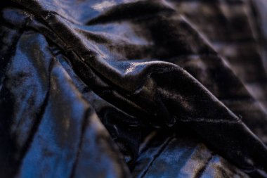 Siyah ve sade, yanardöner, kadife, kıvrık kumaş. Perde.