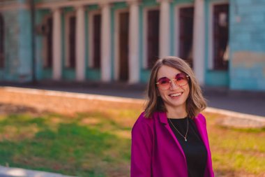 Parlak takım elbiseli, şık giyinmiş bir kız şehirde dolaşıp eğleniyor. Biçim.