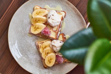 Büyük gri seramik tabak taze Belçika tatlı waffle 'ı, dondurma, çilek, muz ve konsantre süt. Lezzetli kahvaltı ve tatlı..