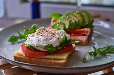 Haşlanmış yumurtadan oluşan sağlıklı ve güzel bir kahvaltı. Benedict, avokado taze sebzeler, domates ve incir. Siyah ve koyu kahveyle karpuzlu tost..
