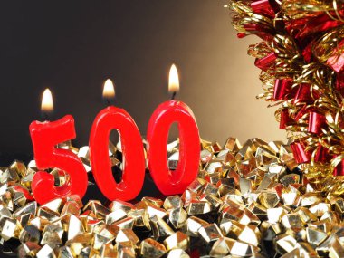 Nr. 500 gösterilen doğum günü Yıldönümü mum. Yanan kırmızı mum bir yıldönümü veya doğum günü arka plan için iyi.