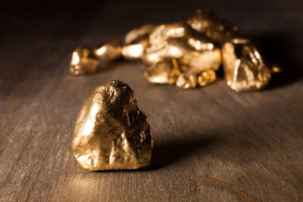 golden nuggets on wooden table