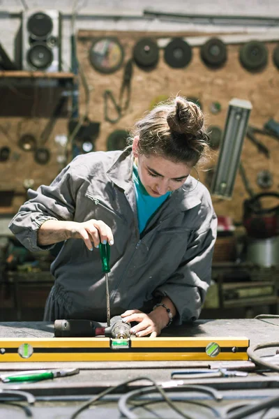 Mujer joven herramienta de fijación en el trabajo — Foto de Stock