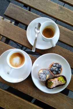 İtalyan kahve molası. Espresso ve macchiato kahve bardak ve bir tabak küçük tatlılar üstten görünüm