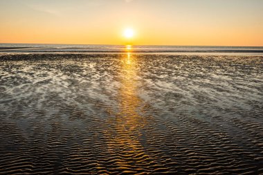 Danimarka 'da kumsalda güzel bir gün batımı. Güneşli doğa geçmişi. Güneşli açık gökyüzü