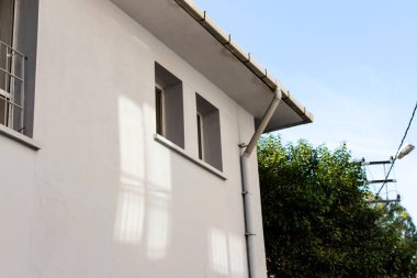 beyaz duvarları ve gökyüzü ile kısa bir yapı bir köşeden