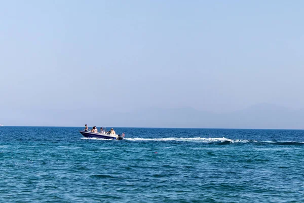 bir sahil köyü'nde plajına yakın bir motorlu tekne yelken.