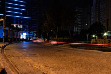 uzun pozlama sakin bir sokak araba kırmızı ışık ile karanlık gece çekiminden. izmir/Türkiye fotoğraf aldı.