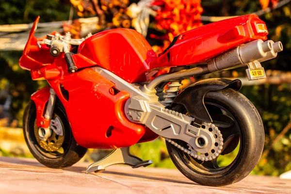 A isolated closeup red toy motorcycle with warm colors- back vie — Stock Photo, Image