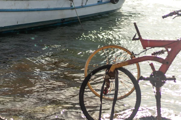 Die Leute stellen ein Fahrrad an die Küste und ein Boot ist da — Stockfoto