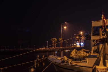 iyi görünümlü gece sahnesi - bir tekne ve şehir ışıkları var