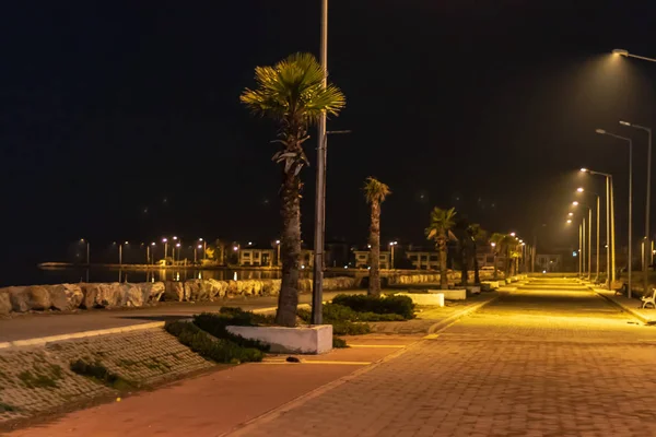 Una amplia vista de la noche disparar desde la carretera costera - palmeras y la ciudad —  Fotos de Stock