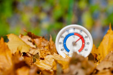 Sıcak sıcaklık - sıcak Hint yaz ya da küresel ısınma kavramı gösterilen açık termometre ile celsius ölçeğinde altın akçaağaç yaprakları