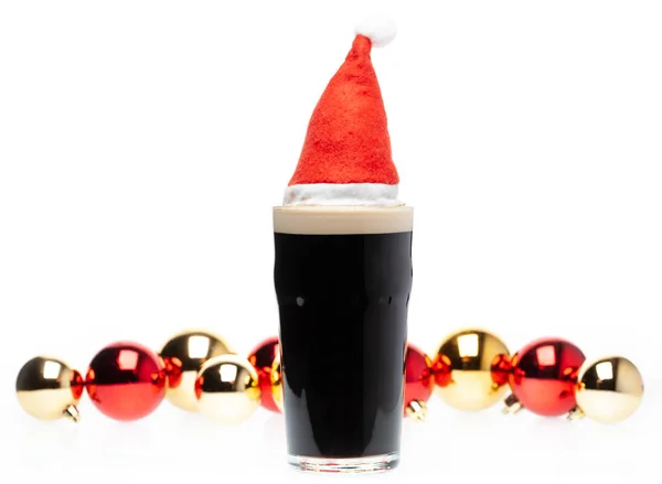 黑暗啤酒在品脱玻璃与圣诞节红色帽子和圣诞节 — 图库照片