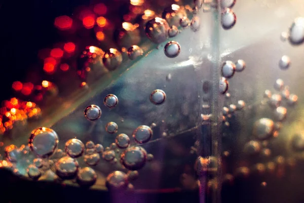 the bubbles in a glass of dark fizzy drink