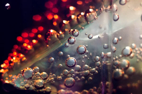 the bubbles in a glass of dark fizzy drink