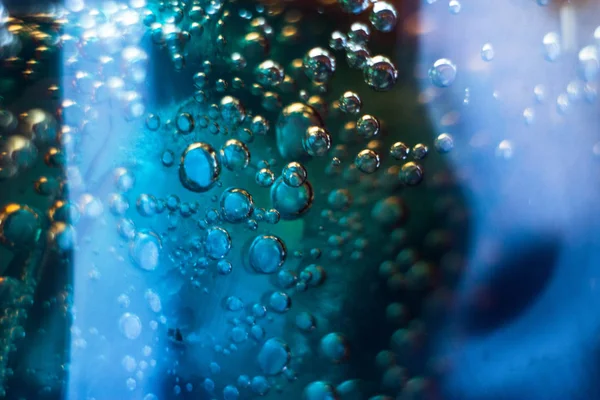 Air bubbles on a piece of ice in a soda liquid. Soda, water, bubbles, ice, texture, glass, glass, curve,