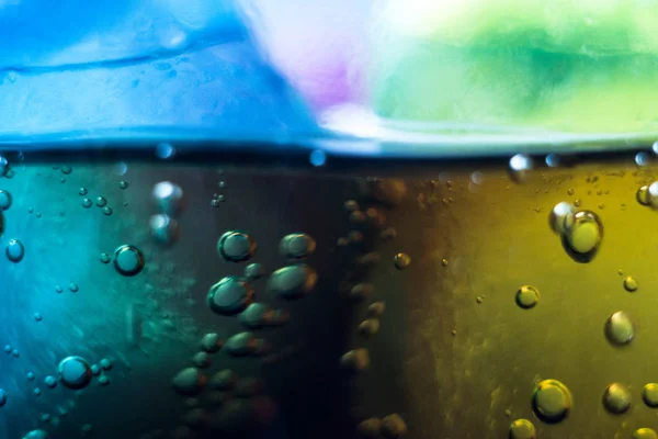 Air bubbles on a piece of ice in a soda liquid. Soda, water, bubbles, ice, texture, glass, glass, curve,