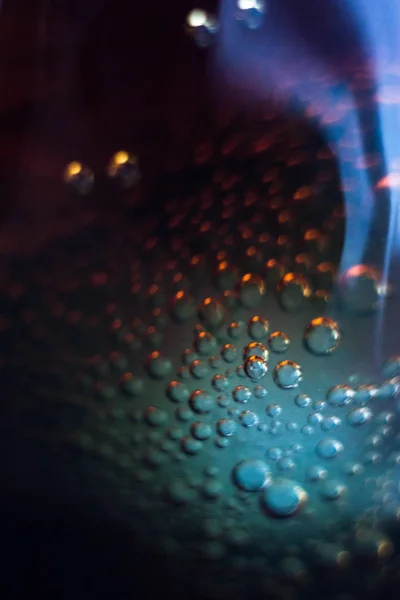 Air bubbles on a piece of ice in a soda liquid. Soda, water, bubbles, ice, texture, glass, glass, curve,