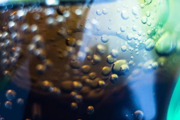 Air bubbles on a piece of ice in a soda liquid. Soda, water, bubbles, ice, texture, glass, glass, curve,