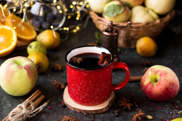 mulled wine in a red mug. hot spiced wine with cinnamon and star anise