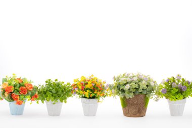 Kumaş ve plastik dekorasyon için yapılan beyaz arka plan üzerinde renkli sahte çiçek satırları.