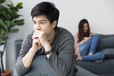 Asyalı erkek ve kadın kanepe kanepede iyi bak. Her kişinin gevşeme ile. Lüks odasında.