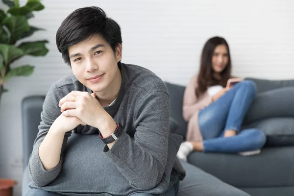 Asyalı erkek ve kadın kanepe kanepede iyi bak. Her kişinin gevşeme ile. Lüks odasında.