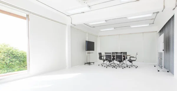 Group of conference table and chairs in white and wide office with television screen without anyone in room
