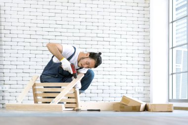 Tamirci, ahşap masa ekipmanları ile montaj olarak çalışan genç adam, bir beyaz tuğla blok için eve DIY ve kendini service.in ofis orada kavramdır.