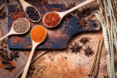 Coloful çeşitli baharat ve otlar doğal doku tahta kaşık ahşap plaka yandı.